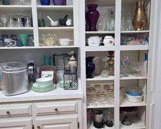 Kitchen items including ice-maker, slow cooker, toaster, microwave (not shown), antique glassware