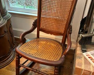 Antique Victorian-style rocking chair with walnut frame and caned seat and backrest