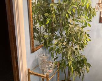 faux ficus tree, gold-framed mirror, gold and glass 3-shelf display