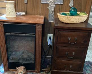 Heat Surge Amish electric fireplace, small chest, crosses, and a cat