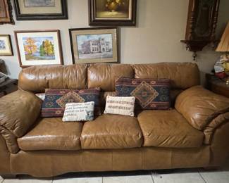 Leather couch, decorative pillows, art, prints