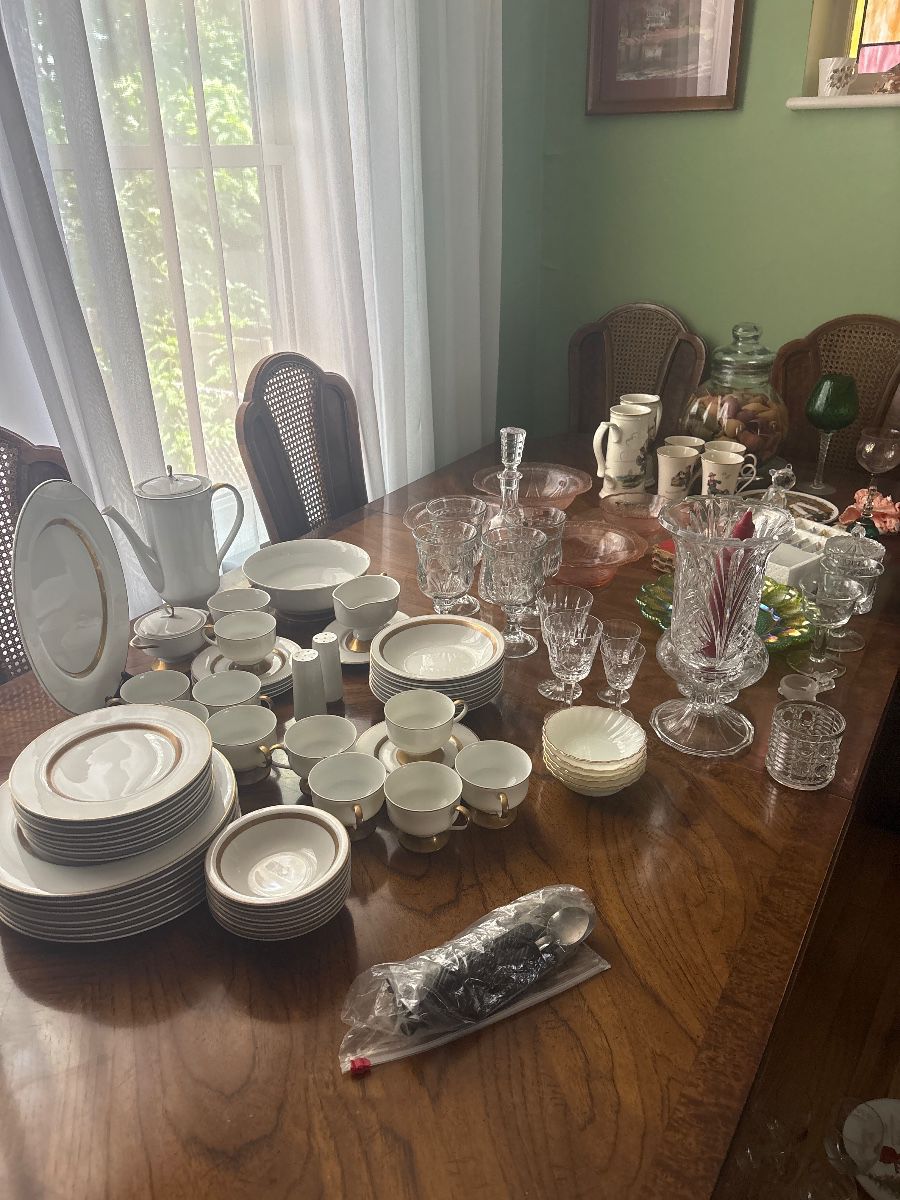 Vintage dishes and depression glass and solid wood dinning room table with chairs