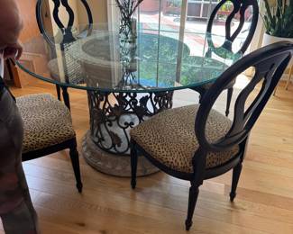 Round Glass Dining Table with Ornate Pedestal Base and Leopard Print Upholstered Chairs