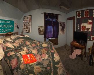 Bedroom with quilts, bedding, signs and furniture