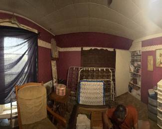 Bedroom full of craft supplies and antique wall hangings