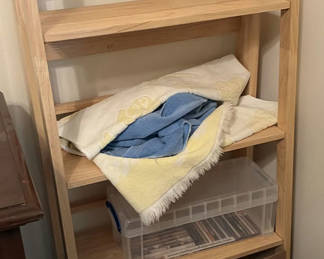 Lot 263: Wooden open-shelf storage with linens and decor items