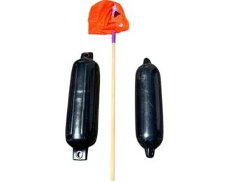 Two Black Inflatable Boat Fenders And An Orange Mesh Fishing Net