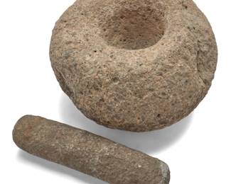 1064 A California carved stone mortar and pestle Pre-historic or later The mortar with a formed globular exterior and an elongated pestle 2 pieces Mortar: 11" H 16.5" W x 16" D; Pestle: 14.75" L x 3.375" Dia. approximately Estimate: $200 - $300