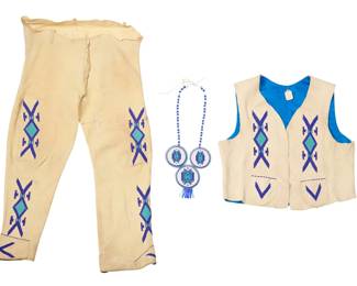 1369 A Plateau style beaded hide vest and pants set Mid-20th century Each embellished with tonal blue beadwork panels of floating diamonds conjoined with chevrons, comprising a vest with blue brocade fabric back and interior, a pair of conforming beaded hide pants, and a bead necklace featuring three beadwork plaques 3 pieces Vest: 20" H x 21.5" W (across back at underarms); Pants: 38" H x 19" W at front; inseam: 29.5"; Necklace: 30" L x 6" H Estimate: $200 - $400