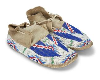 1353 A pair of Plains beaded hide moccasins Mid-20th century Each with polychrome beaded geometric designs 2 pieces Each: 10.375" L x 4.25" W Estimate: $200 - $400