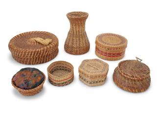 1063 A group of seven Native American baskets Early/mid-20th century Comprising pine needle and sweetgrass: a vase, bowl, lidded basket, and pincushion; and three Northwest Coast polychrome twined baskets, two with lids 7 pieces Lidded pine needle: 3.25" H x 9.5" Dia.; Vase: 7" H x 5.25" Dia.; Smallest: 2.25" H x 4.375" Dia. Estimate: $200 - $300