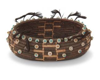 1233 A Pomo beaded gift basket Early 20th century; Central California The coiled basket finely woven with geometric motifs in negative and adorned with shell disc beads, glass beds, and quail topknots 1.75" H x 5.125" W x 3.625" D Estimate: $700 - $900