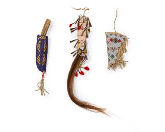 1391 Two Plains or Plains style beaded hide sheaths and holster Mid-20th century and later Comprising a knife sheath with horsehair and tin cones, another sheath and metal knife with wood handle, and a pictorial pistol holster with thunderbird and floating diamond motifs and fringe 3 pieces Blue sheath: 8" L; Other: 8.25" L; Pistol holster: 8" H x 5" W Estimate: $400 - $600