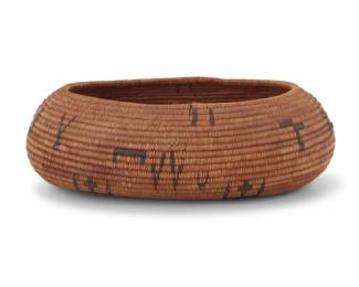 1236 A Pomo oval gift basket Early 20th century; Central California The coiled basket finely woven with floating symbols 1.75" H x 5.5" W x 4" D Estimate: $500 - $700
