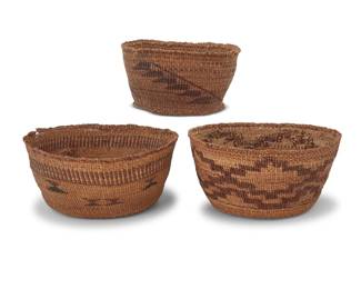 1052 Three Klamath baskets Early 20th century; Northern California/Oregon The twined baskets each with geometric banding 3 pieces Largest: 3.625" H x 8.625" Dia.; Smallest: 3.625" H x 6" Dia. Estimate: $500 - $700