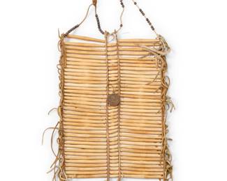 1381 A Northern Plains hairpipe breastplate Late 19th/early 20th century Mounted with James Monroe Peace Medallion, dated 1817 Carved bone, wire, and hide, with leather fringe, cut copper cones, and metal beading 16.5" H x 11.5" W Estimate: $1,000 - $2,000