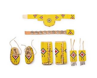 1397 A set of Plains beaded accessories Late 20th/early 21st century Comprising a belt with metal ornaments, arm bands, headdress, leg bands, and a pair of moccasins in yellow, black, red, and white, the bands with cut tin fringe accents 8 pieces Each leg band: 10" L x 5" W; Belt: 22" L; Headband: 20.5" L; Each moccasin: 7.5" L x 4" W Estimate: $200 - $400