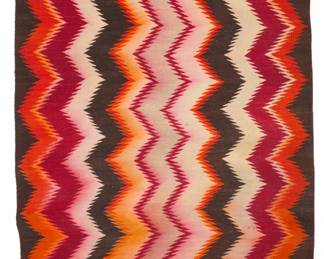 1080 A Navajo regional eyedazzler rug Mid-20th century, Diné Woven in light orange, dark orange, red, cream, and dark brown wool 70.25" H x 41.25" W Estimate: $300 - $500