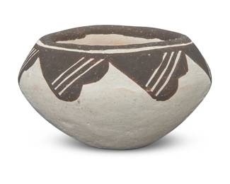 1074 Lucy M. Lewis (1898-1992, Acoma Pueblo) A miniature pottery jar, mid-20th century Signed to underside: Lucy M. Lewis. With black repeated band to rim and shoulder on a white slip ground 1.125" H x 1.875" Dia. Estimate: $200 - $400