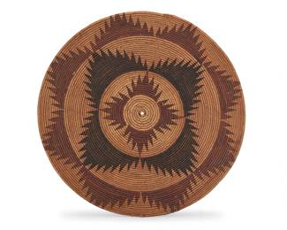 1040 A Miwok polychrome basketry gambling tray Early 20th century; Central California The coiled tray with three rings of serrated mountains 2.5" H x 20.375" Dia. Estimate: $800 - $1,200