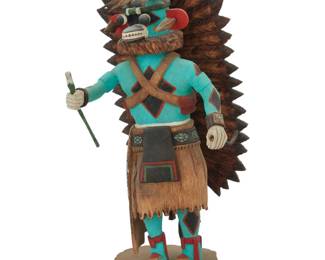1402 Tino Youvella (b. 1940, Hopi-Tewa/Laguna Pueblo) A polychrome carved cottonwood "Blue Ahite" katsina, late 20th century Signed and inscribed to underside: [artist's sun cipher] / Tino Youvella / Blue Ahite / Uncle of All / Mix Kachinas / Hopi Depicted with elaborate headdress and holding a whip Overall: 13" H x 6" W x 5.75" D Estimate: $200 - $400