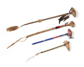 1383 A group of Native American style skull crackers Mid/late 20th century Each carved stone and wood, one with incised designs to the stone, two with beaded handles, each with hide elements 4 pieces Longest: 24.75" H x 6.75" W x 2.25" D; Smallest: 16.25" H x 5.625" W x 1.875" D Estimate: $300 - $500