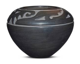 1069 Margaret Tafoya (1904-2001, Santa Clara Pueblo) A large blackware pottery jar, mid/late 20th century Incised to underside: Margaret Tafoya With deeply carved abstract Avanyu motif to shoulder 8.375" H x 11.625" Dia. Estimate: $800 - $1,200