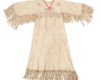 1362 A Plains style beaded hide dress with American flags Mid/late 20th century The long dress with polychrome beaded bands at neckline and shoulders, the front with dual American flag motifs, shield motifs to front and back, and fringed elements to sleeves, sides, and hem, and multiple beaded tassels at center front and back Approximately 58" H (from neckline) x 20" W (across front underarms); sleeves: 19.5" (from neckline), 28" L including fringe Estimate: $1,000 - $2,000
