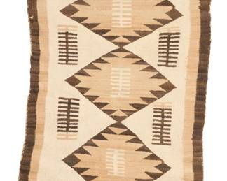 1083 A Navajo regional rug Early 20th century, Diné Woven in dark brown, cream, and tan wool, with three stacked serrated diamonds 44.25" H x 29" W Estimate: $300 - $500