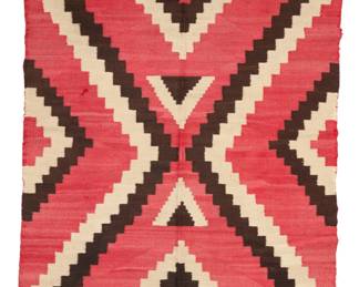1079 A Navajo regional rug Early 20th century, Diné Woven in red, dark brown, and cream wool, with stepped half-diamonds 65.5" H x 44.75" W Estimate: $400 - $600