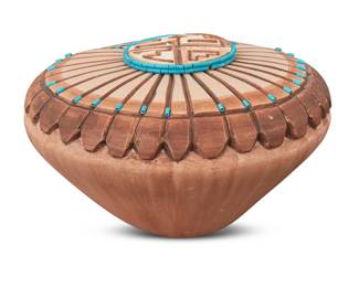 1297 Elvira Polacca Nampeyo (b. 1968, Hopi-Tewa) A carved polychrome pottery lidded seed jar, 1989 Incised and in-filled signature and date to underside: ELVIRA POLACCA NAMPEYO / 89' With inset and mounted turquoise tubular bead accents, carved with a tawa katsina to top 3.125" H x 5" Dia. Estimate: $200 - $400