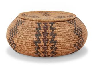 1241 A Yokuts polychrome lidded basket Early 20th century; Central California The coiled basket with alternating columns of stacked checkered diamonds and stacked triangles; the lid continuing the design 2.25" H x 5.125" Dia. Estimate: $500 - $700