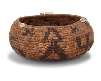 1234 A Pomo beaded gift basket Early 20th century; Central California The coiled basket rim mounted with shell disc beads and a feather, finely woven with alternating whirling log designs and columns of stacked diamonds 2.25" H x 5" Dia. Estimate: $700 - $900