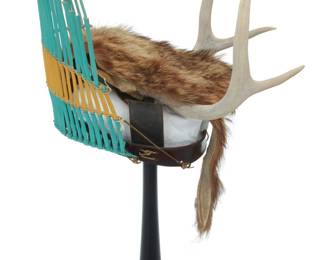 1404 A Southwest deer dancer headdress Mid-20th century Enameled metal, animal pelt, and deer antlers, mounted to a leather headband 11.5" H x 13" W x 14" D Estimate: $200 - $400