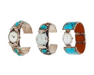 2302 A group of Southwest silver and stone set watch bands & cuffs Mid/late 20th century Variously marked: Effie C / Zuni Three works comprising two watch cuffs and one watch band, including an Effie Calavaza (c. 1927-2019) Zuni watch cuff with set turquoise and applied silver serpents (6.375" inner C x 0.75" H, gap: 1.125"), a silver and set turquoise and coral cuff with elaborate applied silver feather and wire motifs (6.25" inner C x 1" H, gap: 1"), and a watch band with clasp closure in turquoise mosaic inlay (6.25" inner C x 1.125" H with clasp closed), each attached to a different watch face 3 pieces 206.1 grams gross Estimate: $300 - $500