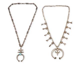 2161 Two Southwest sand cast silver necklaces Mid-20th century Cross naja stamped with two triangles or M Comprising a sterling silver squash blossom bead necklace with a delicate cast coin silver naja (25.5" L x 2.25" H), as well as a single strand silver bead necklace suspending a sterling silver sandcast set turquoise double-cross naja (26.5" L x 3" H) 2 pieces 127.6 grams gross Estimate: $400 - $600