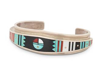 2040 An Ernest Benally Navajo sterling silver and mosaic inlay cuff bracelet Ernest Benally (b. 1958, Diné) Late 20th/21st century Stamped: E. Benally / [hogan pictograph] / Sterling A narrow cuff with geometric and banded multistone inlay featuring turquoise, mother of pearl and coral 6.25" total inner C x 0.75" H, gap: 1.125" 52.3 grams gross Estimate: $200 - $400