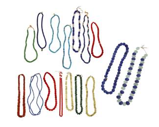 2315 A group of Native American style trade bead necklaces 20th century or earlier Comprising six single strands featuring blue or green glass trade beads including padre beads, four single strands featuring coral or red glass trade beads, and three single strands of green or yellow cut glass saucer disc beads, as well as four chunky single strands with blue, white, or pale green glass beads, including two strands with extra-large beads 17 pieces Largest: 36" L; Smallest: 22" L 2477.99 grams gross Estimate: $200 - $400
