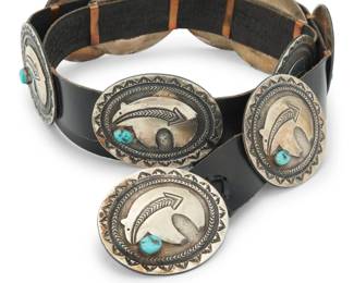 2099 A Brian Kagenvema Hopi sterling silver and turquoise concho belt Brian Kagenvema (b. 20th century, Hopi Pueblo) Late 20th/21st century Stamped: BK / Sterling A heavy belt with nine sterling silver conchos and a matching buckle, each with a silver overlay heartline bear motif with a single set turquoise and heavy stampwork details Buckle and each concho: 2.5" H x 3" W; Belt: 47.5" L x 1.25" H 702.5 grams gross Estimate: $800 - $1,200