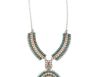2091 A Larry Moses Begay Navajo sterling silver and cluster set turquoise necklace Larry Moses Begay (b. 20th century, Diné) Late 20th century Stamped: LMB / Sterling A chain link necklace featuring a round hinged pendant with concentric rows of petit point turquoise, suspended from two long links with row set turquoise and paper clip chains 27" L x 4.25" H 109.4 grams gross Estimate: $800 - $1,200
