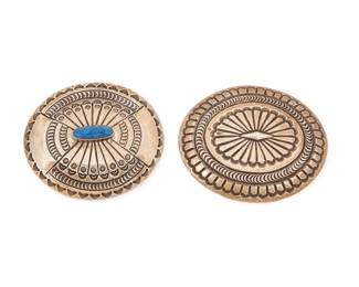 2241 Two Southwest sterling silver concho belt buckles Late 20th century Each variously stamped: C / M / Sterling Comprising a large oval sterling silver concho buckle (3" H x 3.5" W), and a smaller oval sterling silver buckle with stampwork and a central set lapis lazuli (2.75" H x 3.125" W) 2 pieces 133.0 grams gross Estimate: $200 - $400