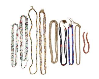 2314 A group of Native American-style trade bead necklaces 20th century Comprising two double strands of blue and red trade beads, three single strands of shell disc beads, and nine strands featuring multiple various trade beads and colored glass beads, including Italian and African-style striped colored beads 14 pieces Largest: 58" L; Smallest: 16.5" L 732.3 grams gross Estimate: $200 - $400
