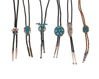 2250 A group of Southwest silver and turquoise bolo ties Mid/late 20th century 6 works:  Tommy Moore (b. 20th century, Diné) A Navajo sterling silver and turquoise bolo tie Stamped: Tommy Moore [script] / Sterling An oval bolo slide with cluster set turquoise, on a braided black leather cord with silver cone tips Bolo slide: 1.75" H x 1.5" W; cord: 37" L  A group of Southwest silver and turquoise bolo ties Each unmarked Comprising two sterling silver and stone inlay bolos, one a Zuni Shriner's symbol slide with turquoise inlay, and one a Zuni Knifewing figure with multistone inlay, as well as a Hopi-style incised sterling silver katsina dancer slide with set turquoise, and two concho-style mixed metal slides with set blue stones, each bolo slide on a braided leather cord with silver cone or mixed metal tips 5 pieces Largest bolo slide 1.5" H x 2" W; Smallest: 1.25" H x 1" W; cords: 38" L to 33" L  6 pieces total 152.3 grams gross Estimate: $400 - $600
