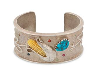 2045 A Southwest cast sterling silver and gem-set cuff bracelet Andrew "Redhorse" Alvarez (b. 1953, Non-Native) Late 20th century Etched signature to interior A chunky cuff featuring an ear of corn in applied silver and carved mother of pearl, with set turquoise and scattered faceted stones and corn stalk motifs 6.75" total inner C x 1.25" H, gap: 1.125" 121.2 grams gross Estimate: $500 - $700