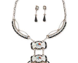 2071 A set of Juan & Charlene Chico Zuni Sunface silver and multistone inlay jewelry Juan and Charlene Chico (b. 20th century, Zuni Pueblo) Late 20th century Etched signature verso: Juan & Charlene Chico / Zuni An elaborate multistone inlay pictorial link necklace with two articulated Sunface plaques of mother of pearl, turquoise, coral, and black stone, all suspended from two narrow inlay links and handmade paperclip chains, as well as a pair of matching earrings 3 pieces Necklace: 20" L x 4.25" H; Earrings: 2" H 78.0 grams gross Estimate: $500 - $700