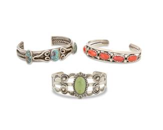 2263 A group of Southwest sterling silver and set stone cuff bracelets Early/mid-20th century One stamped: Sterling Three works comprising an early three wire sterling cuff with three set turquoise stones, and silver wire overlay accents, a Fred Harvey-style three wire sterling cuff with central set turquoise and stampwork accents, and a narrow three wire sterling cuff with row set coral cabochons and silver ball accents 3 pieces Largest: 7" total inner C x 1.25" H, gap: 1.375"; Smallest: 6" total inner C x 0.625" H, gap: 1" 91.1 grams gross Estimate: $400 - $600