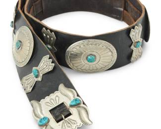 2101 A Southwest style German silver and turquoise concho belt Early/mid-20th century Etched to buckle verso: German Silver A chunky belt featuring a rectangular silver repoussé buckle, six oval conchos, and seven butterfly spacers, each with stampwork and a central set turquoise stone, and all mounted to a wide leather belt strap Buckle: 2.625" H x 3.375" W; Each concho: 2.375" H x 3.125" W; Spacers: 2.375" H x 1.25" W; Belt: 45.625" L x 2.5" H 606.9 grams gross Estimate: $600 - $800