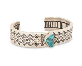 2025 A Southwest sterling silver and turquoise cuff bracelet Late 20th/21st century Unmarked A chunky sterling silver cuff with a stampwork band and asymmetrical set turquoise, with ridged banding to interior 6.5" total inner C x 0.625" H, gap: 1.125" 60.7 grams gross Estimate: $300 - $500