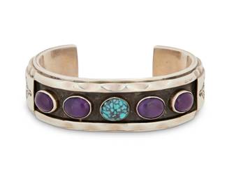 2043 A Phillip Guerro & Yellowhorse Navajo sterling silver and set stone cuff bracelet Phillip Guerro (b. 20th century, Navajo) Late 20th century Stamped: PTG [Phillip Guerro] / W/Yellowhorse / Sterling A chunky cuff with shadowbox row set sugilite and turquoise cabochons, and stampwork to terminals 6.375" total inner C x 0.75" H, gap: 1.25" 90.7 grams gross Estimate: $400 - $600