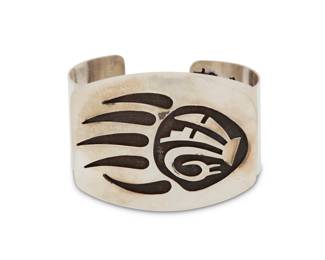 2203 A Hopi Pueblo style sterling silver overlay cuff bracelet Late 20th century Stamped: Sterling A chunky cuff with large overlay plaque featuring a bear claw motif with geometric accents 7" total inner C x 2" H, gap: 1" 82.1 grams Estimate: $200 - $400